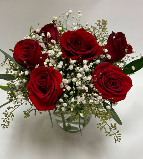 six red rose arrangement in a glass vase