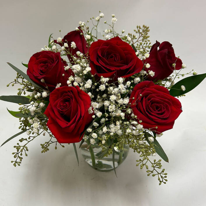 six red rose arrangement in a glass vase