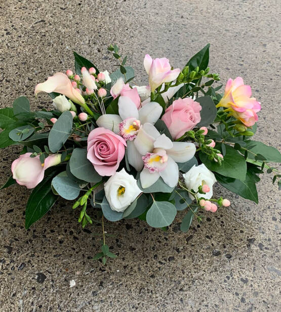 An image of a white and pink flower arrangemet with white orchids and pink roses