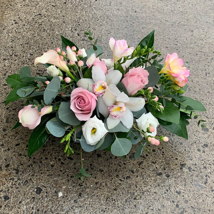 An image of a white and pink flower arrangemet with white orchids and pink roses