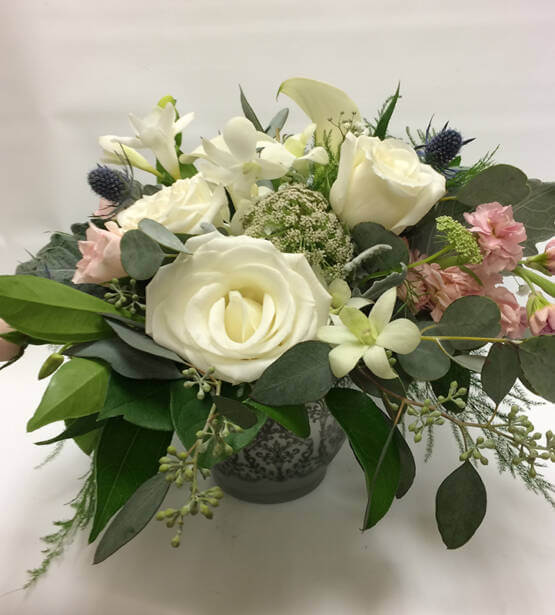 An image of a white and pink floral arrangements with greenery