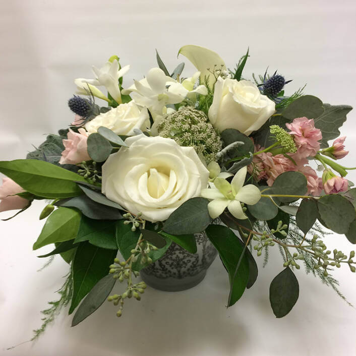 An image of a white and pink floral arrangements with greenery