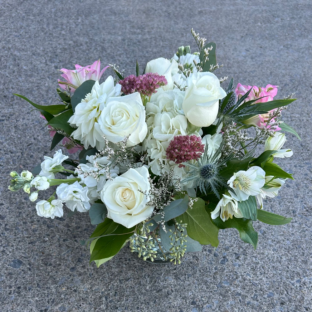 An image of a white and pink floral arrangements with greenery