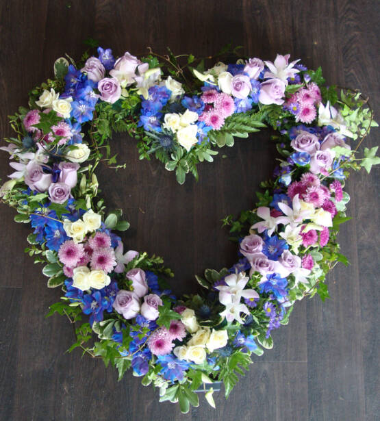 a pink and purple heart shaped flower arrangement