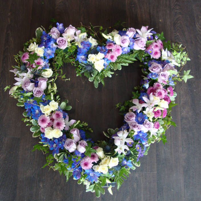 a pink and purple heart shaped flower arrangement