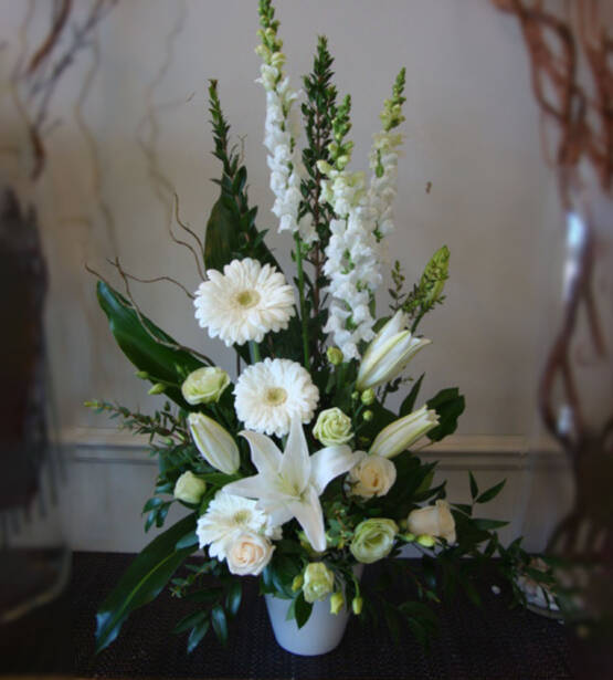 a large white sympathy floral arrangement