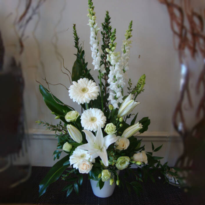 a large white sympathy floral arrangement