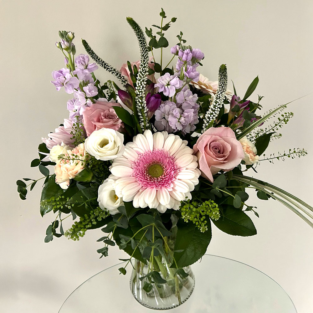 a multicoloured spring floral arrangement in a glass vase.
